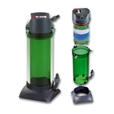 Small external filter with a green canister on its grey stand, next to its open canister, its foams and its pump head