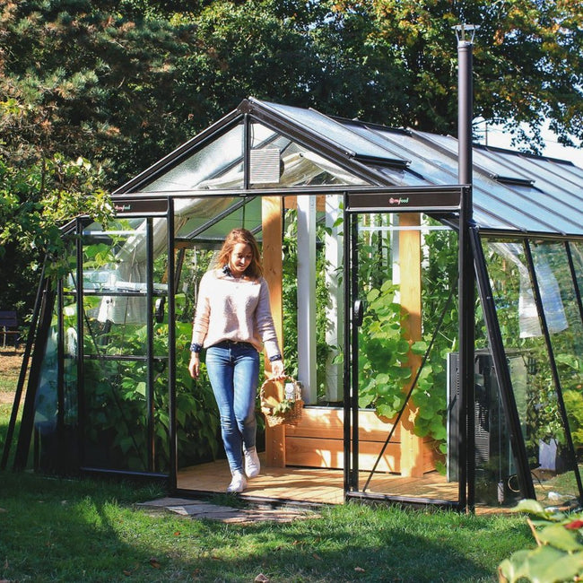 Serre d'aquaponie Myfood Family en verre au fond d'un jardin
