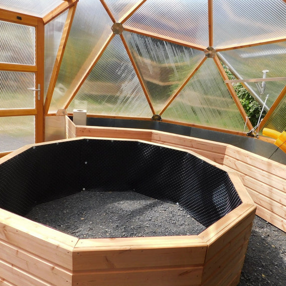 Intérieur d'une serre dôme de 5,3 m avec jardinière centrale octogonale et bacs en bois
