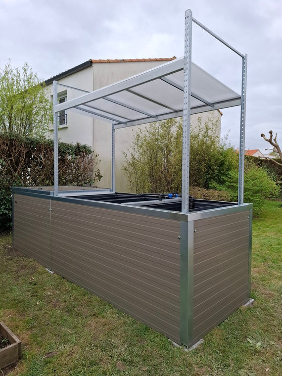 Symbiose installé sur une pelouse, bacs encore vides sous la structure d'ombrage en acier galvanisé