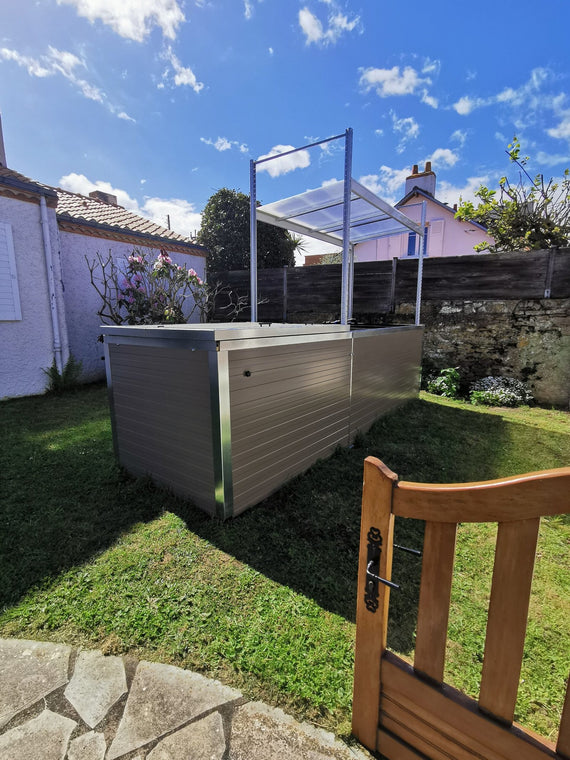 Symbiose installé au fond d'un jardin ensoleillé, vu depuis une terrasse