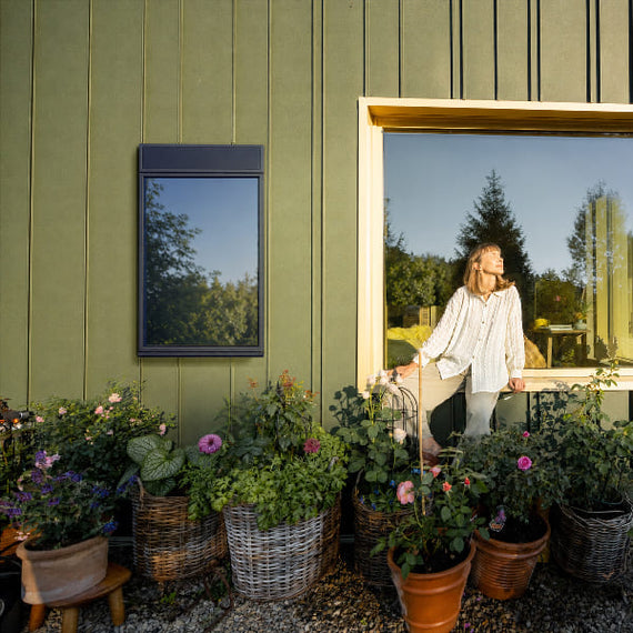 Chauffage solaire Sunaero installé sur le mur d'une maison au jardin
