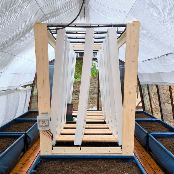 Structure en bois de la serre Myfood Family qui porte les tours de culture verticales, avant plantation