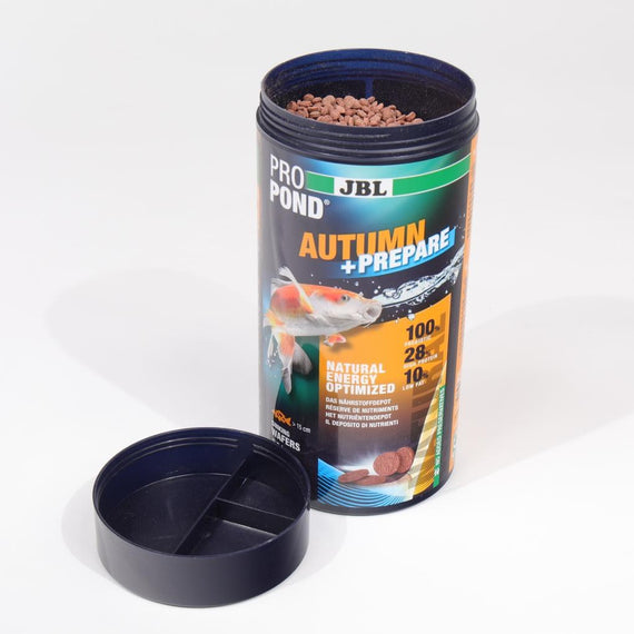 Boîte ouverte remplie de granulés bruns en forme de pastilles, couvercle doseur posé devant