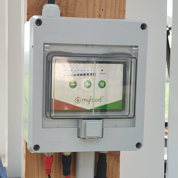 Boîtier de mesure connecté de la serre Myfood Family, fixé à la structure en bois des tours de culture