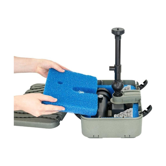 Mains qui retirent la mousse filtrante bleue du boîtier ouvert du filtre de bassin Filtrapond