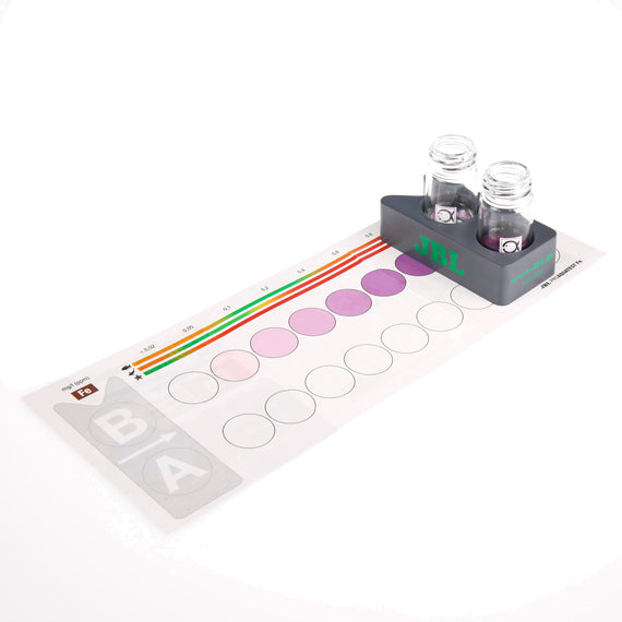 Nuancier du test de fer posé sous le bloc comparateur et ses deux éprouvettes, neuf champs de couleur de 0,02 à 1,5 mg par litre